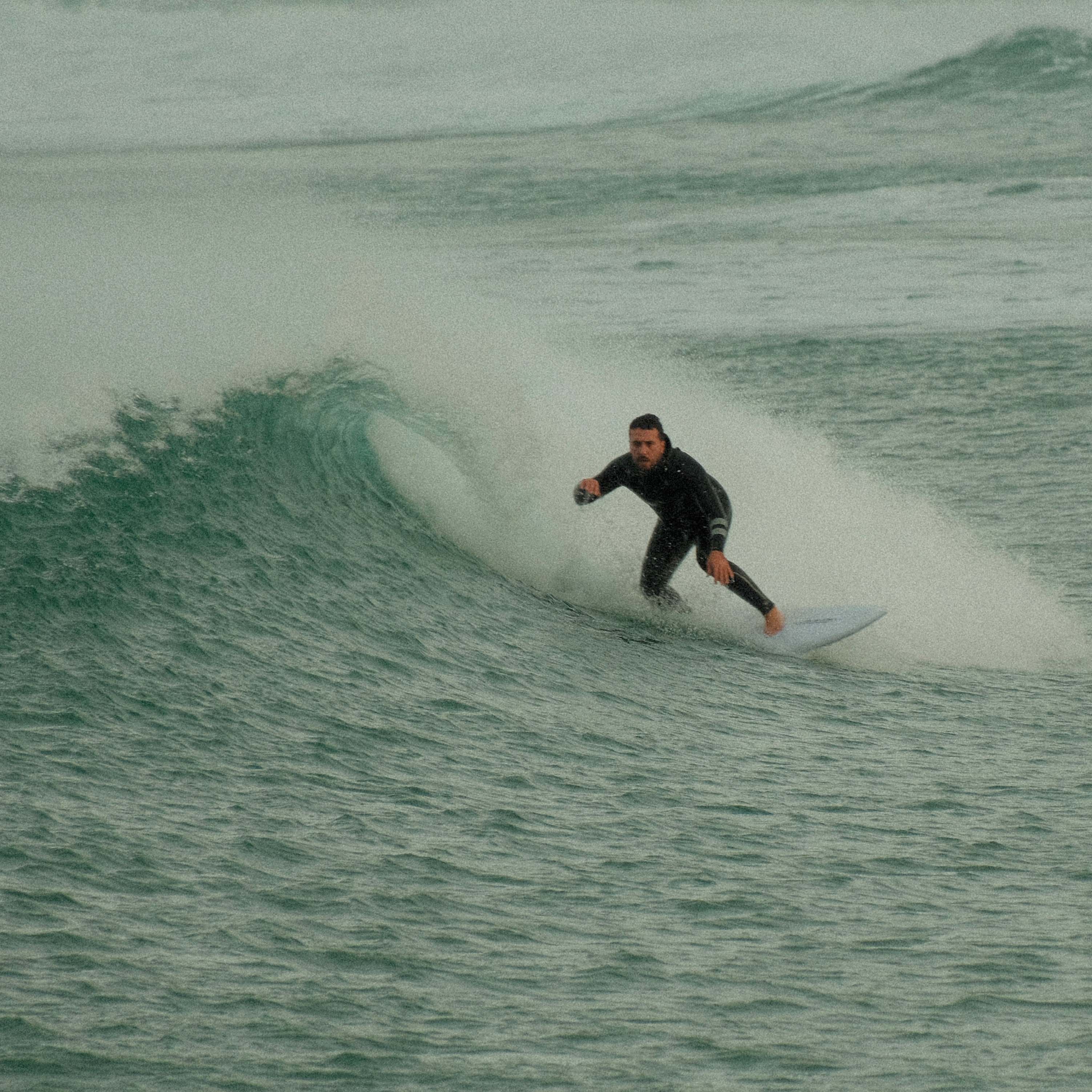 Erik carving a wave on a grey morning